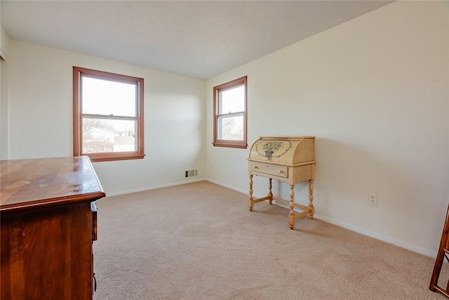 carpeted office space featuring visible vents and baseboards