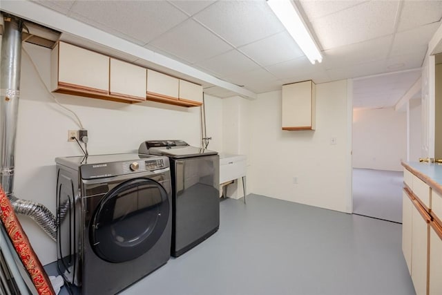 clothes washing area featuring cabinet space, independent washer and dryer, and a sink