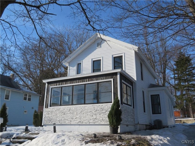 view of front of home featuring central AC unit and a sunroom