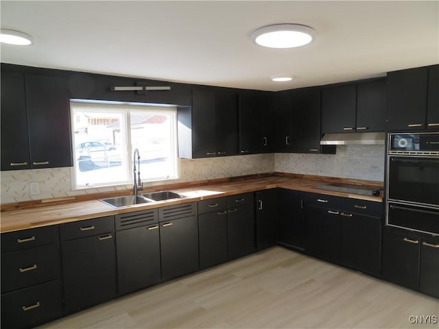 kitchen with a warming drawer, black appliances, a sink, wood counters, and dark cabinetry