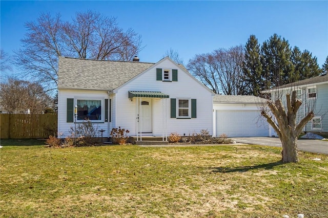 view of front of property featuring a shingled roof, a front lawn, fence, driveway, and an attached garage