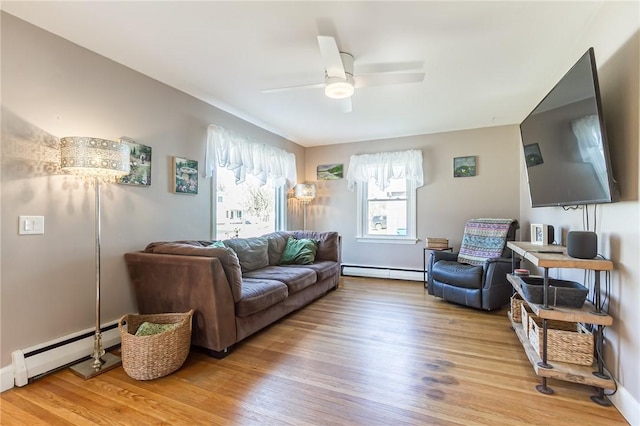 living room featuring wood finished floors, a ceiling fan, and a baseboard radiator