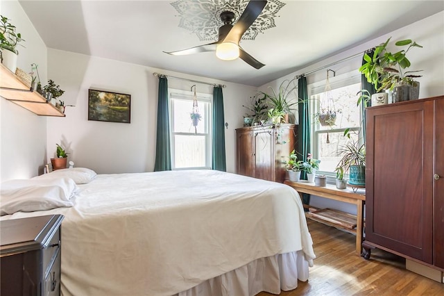 bedroom with multiple windows, light wood-style flooring, and ceiling fan