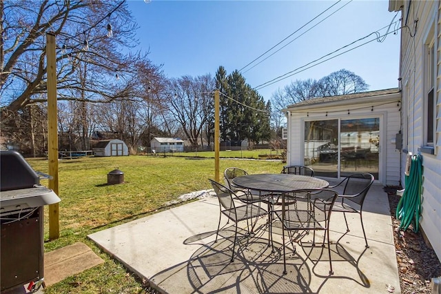 view of patio / terrace featuring outdoor dining area, a grill, an outdoor structure, and a shed