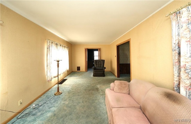 living area featuring crown molding and carpet floors