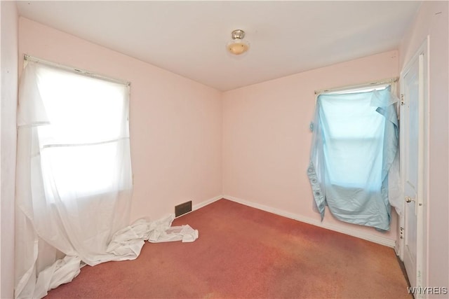 spare room featuring visible vents, baseboards, and carpet flooring