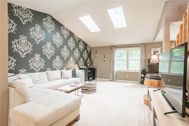 living room featuring lofted ceiling with skylight, carpet flooring, wallpapered walls, baseboards, and an accent wall