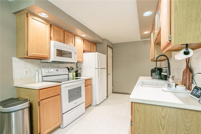 kitchen with light countertops, decorative backsplash, recessed lighting, white appliances, and a sink