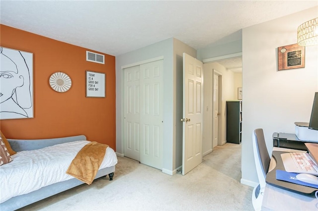 bedroom featuring baseboards, visible vents, a closet, and light carpet