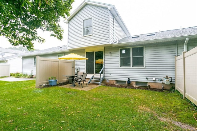 back of house with entry steps, a yard, and a patio area