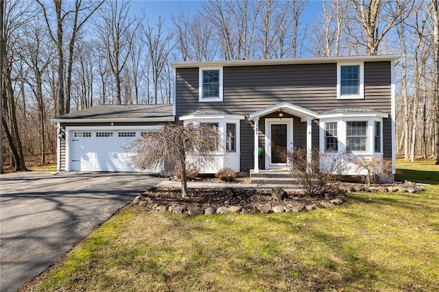 view of front of house featuring an attached garage, driveway, and a front lawn