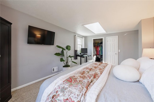 bedroom featuring visible vents, a closet, carpet floors, a skylight, and baseboards