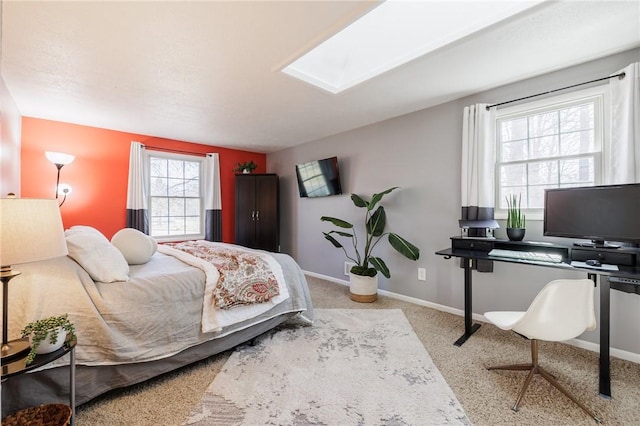 bedroom featuring a skylight, baseboards, and carpet floors