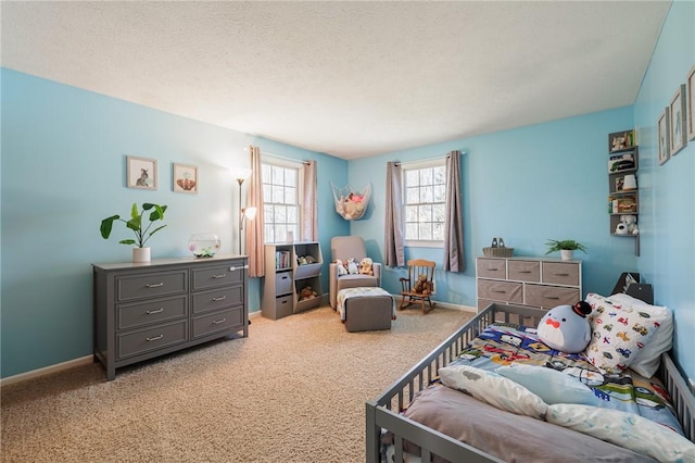 bedroom with light carpet, a textured ceiling, and baseboards