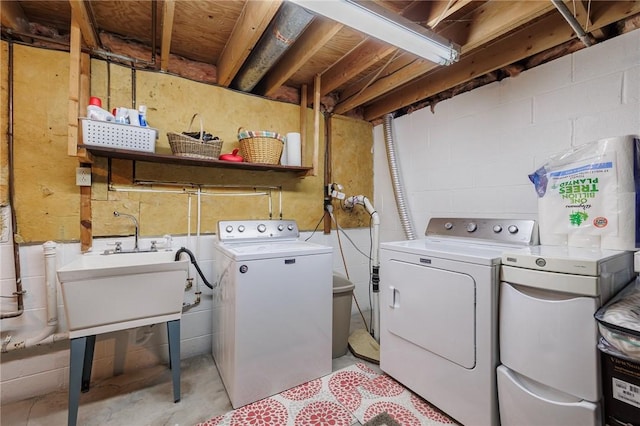 clothes washing area featuring laundry area, washer and dryer, and a sink