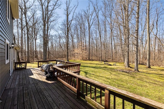 wooden deck featuring a view of trees and a lawn