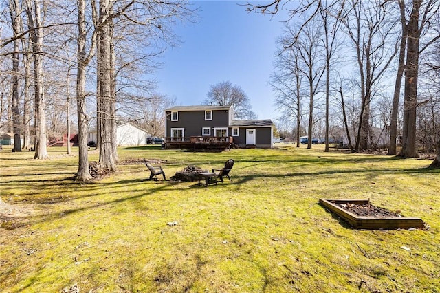 view of yard with a deck and an outdoor fire pit