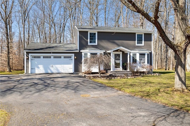 view of front of home featuring aphalt driveway, a front yard, and an attached garage