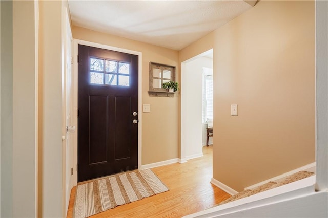 foyer featuring light wood-style floors and baseboards