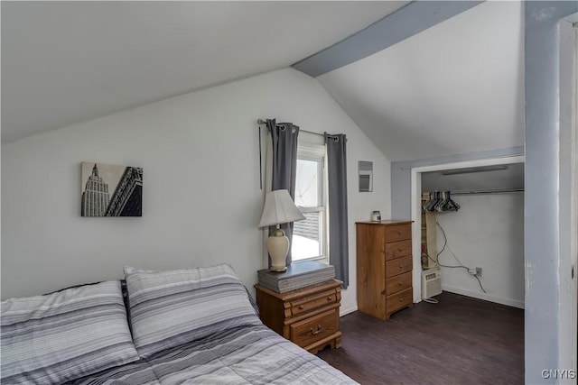 bedroom with dark wood finished floors, vaulted ceiling, baseboards, and a closet