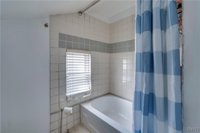 full bath featuring a bath, a shower with curtain, and vaulted ceiling