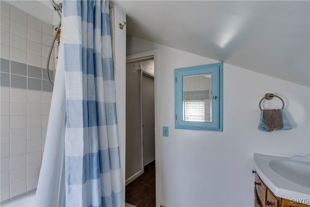 bathroom featuring wood finished floors, curtained shower, vanity, and vaulted ceiling