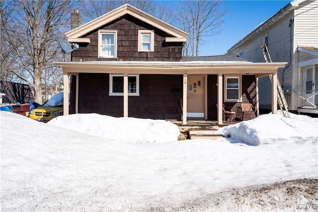 view of front of home featuring covered porch and a chimney