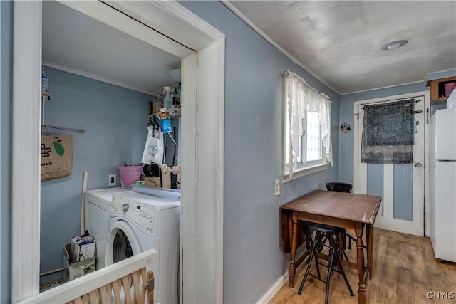 laundry area with washing machine and clothes dryer, crown molding, baseboards, laundry area, and wood finished floors