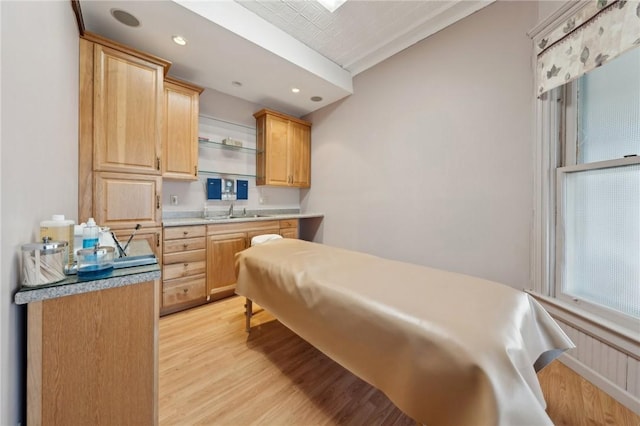 bedroom featuring recessed lighting, light wood-style floors, and a sink