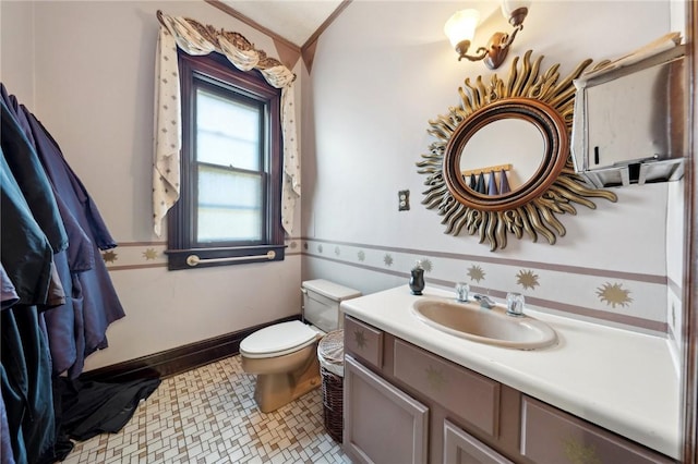 bathroom featuring vanity, toilet, and baseboards