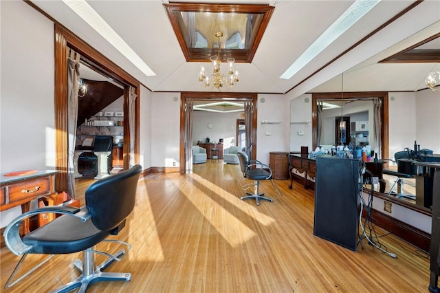 home office featuring lofted ceiling, wood finished floors, baseboards, and a chandelier