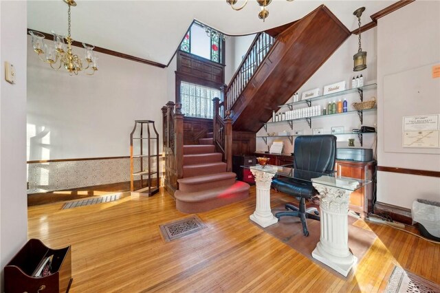 office space featuring a notable chandelier, visible vents, and wood finished floors