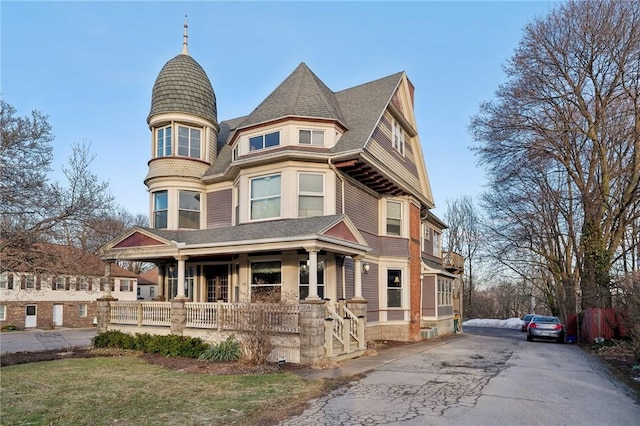 victorian-style house with roof with shingles and covered porch