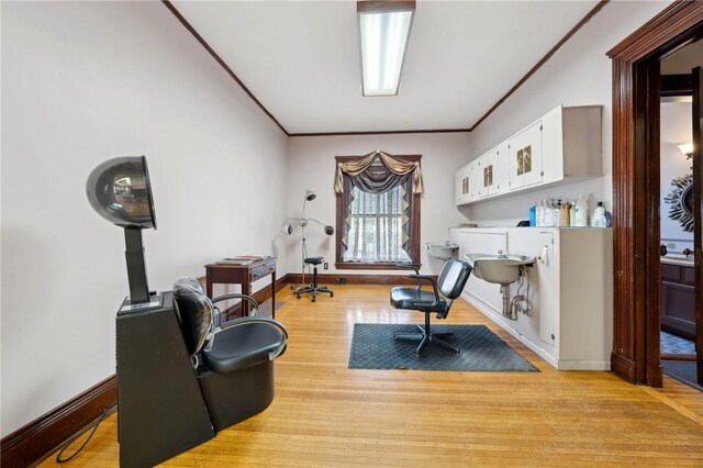 living area featuring light wood-style flooring, baseboards, and ornamental molding