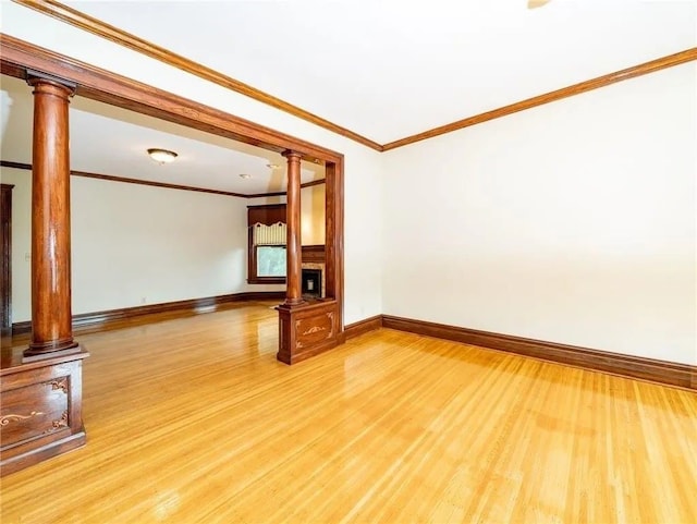 unfurnished living room featuring decorative columns, baseboards, light wood-style flooring, and crown molding