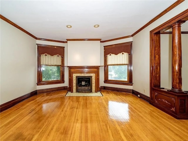 unfurnished living room featuring a fireplace with flush hearth, wood finished floors, baseboards, and ornamental molding