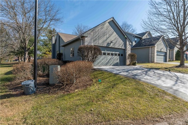 view of side of home with concrete driveway, a lawn, and a garage