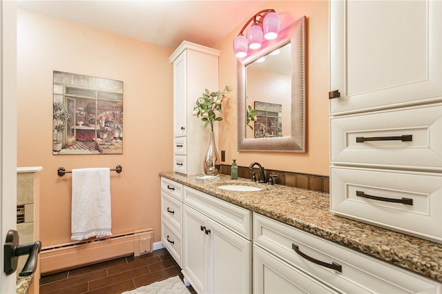 bathroom with vanity, baseboards, a baseboard radiator, and wood finish floors