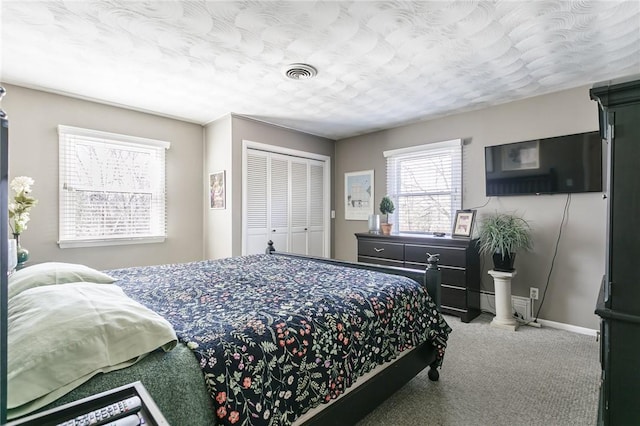 bedroom featuring visible vents, baseboards, a textured ceiling, and carpet flooring