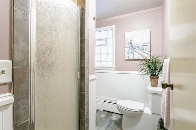 full bath featuring a shower stall, toilet, a baseboard heating unit, and wood finished floors