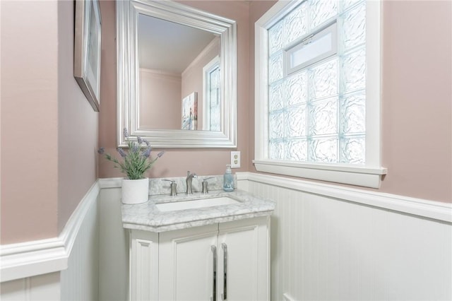 bathroom featuring a wealth of natural light, vanity, and wainscoting