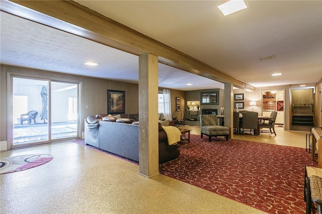 living area featuring stairway and a brick fireplace