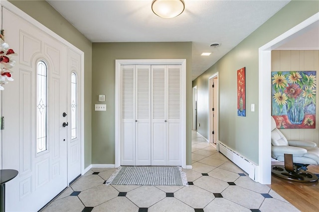 entrance foyer with a baseboard heating unit, baseboards, and visible vents