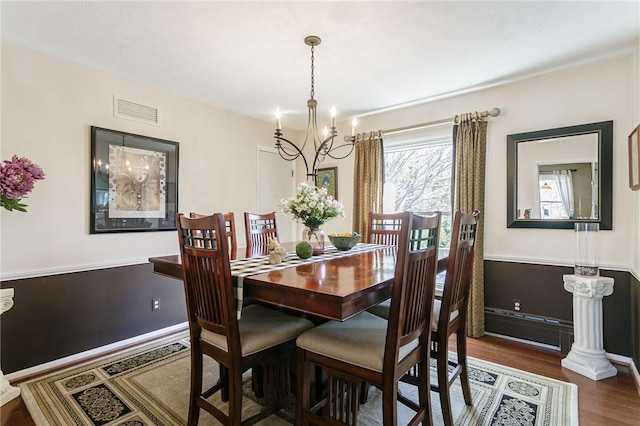 dining room with visible vents, baseboards, an inviting chandelier, and wood finished floors