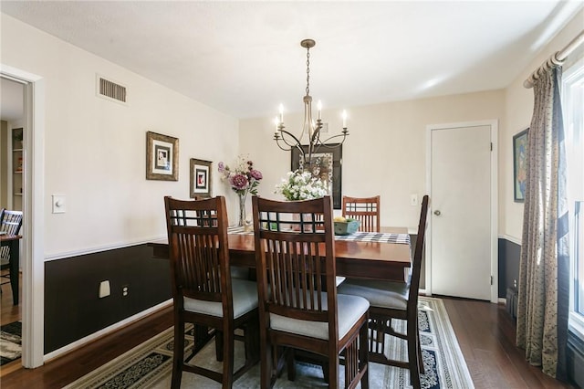 dining area with visible vents, wood finished floors, and a chandelier