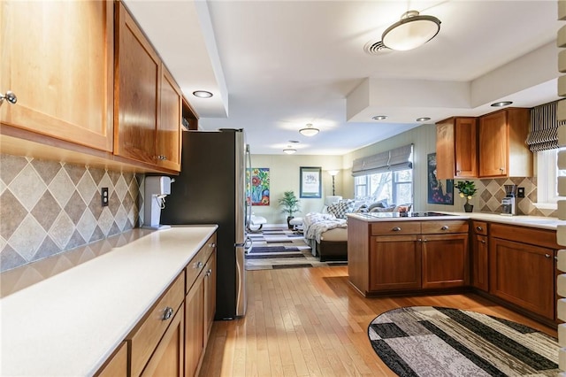 kitchen featuring light countertops, open floor plan, visible vents, and light wood-type flooring