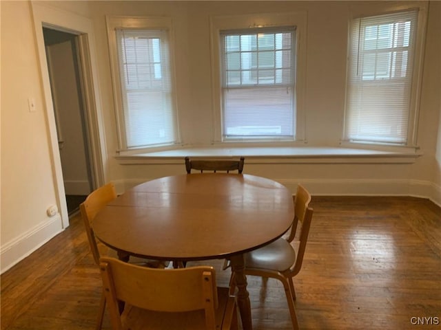 dining area featuring baseboards and wood finished floors