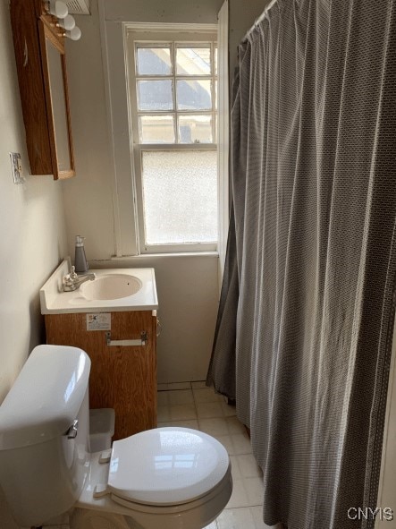 full bath featuring a shower with shower curtain, toilet, vanity, and tile patterned flooring