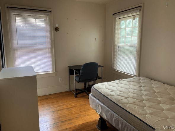 bedroom with baseboards and light wood finished floors