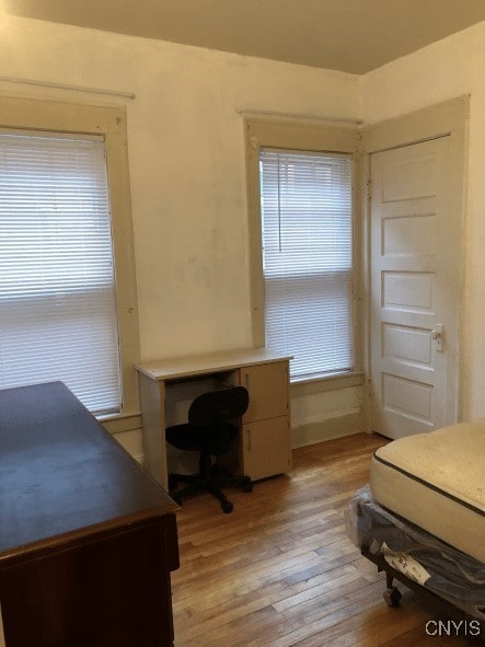 bedroom with light wood-style flooring and multiple windows